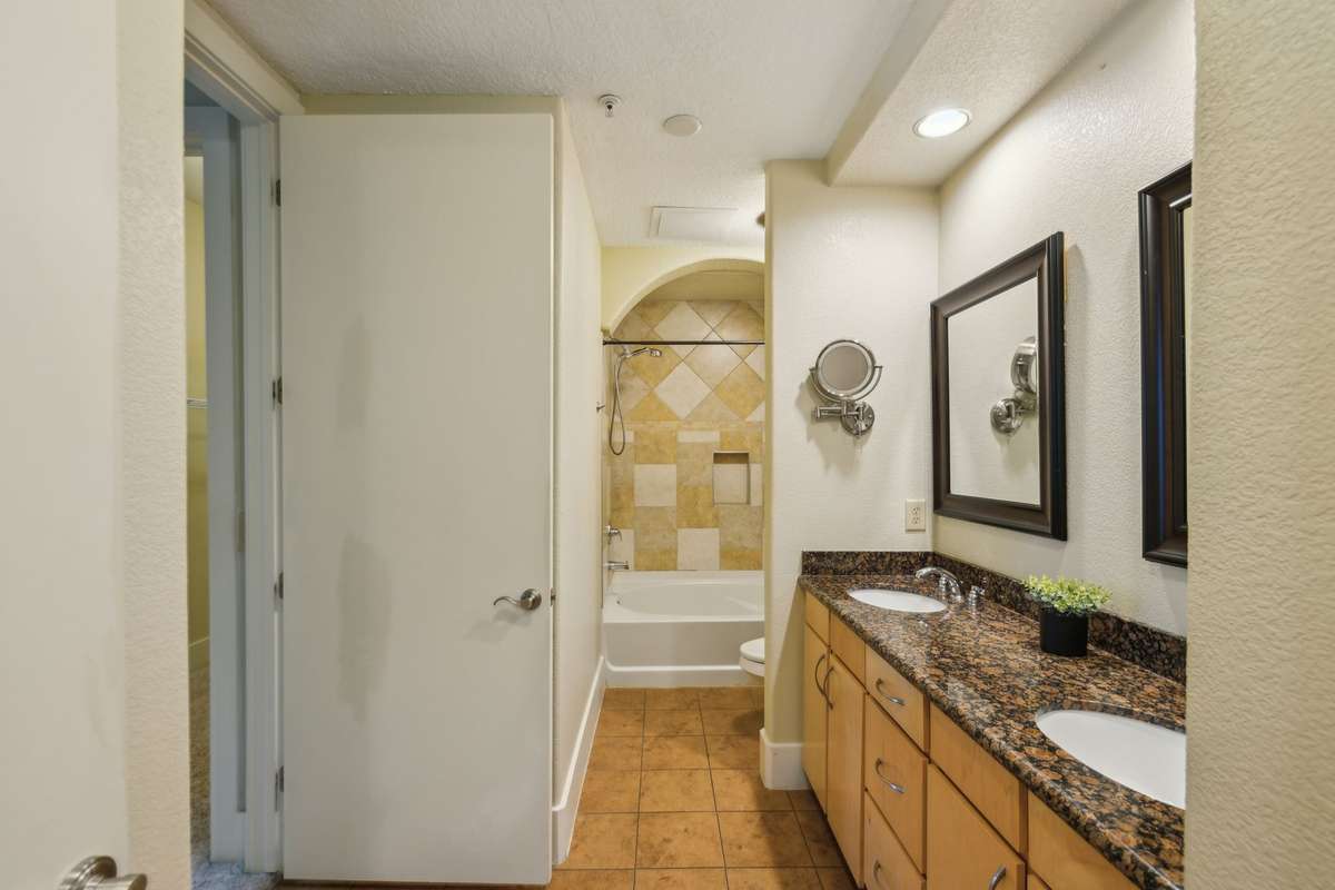 This bath has plenty of space with double vanities, large shower/tub combo and extra shelving.