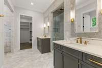 Primary bath with tons of custom tile work and split vanities