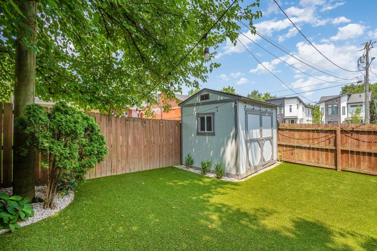 “Tuff Brand” storage shed with a low-maintenance turf backyard.
