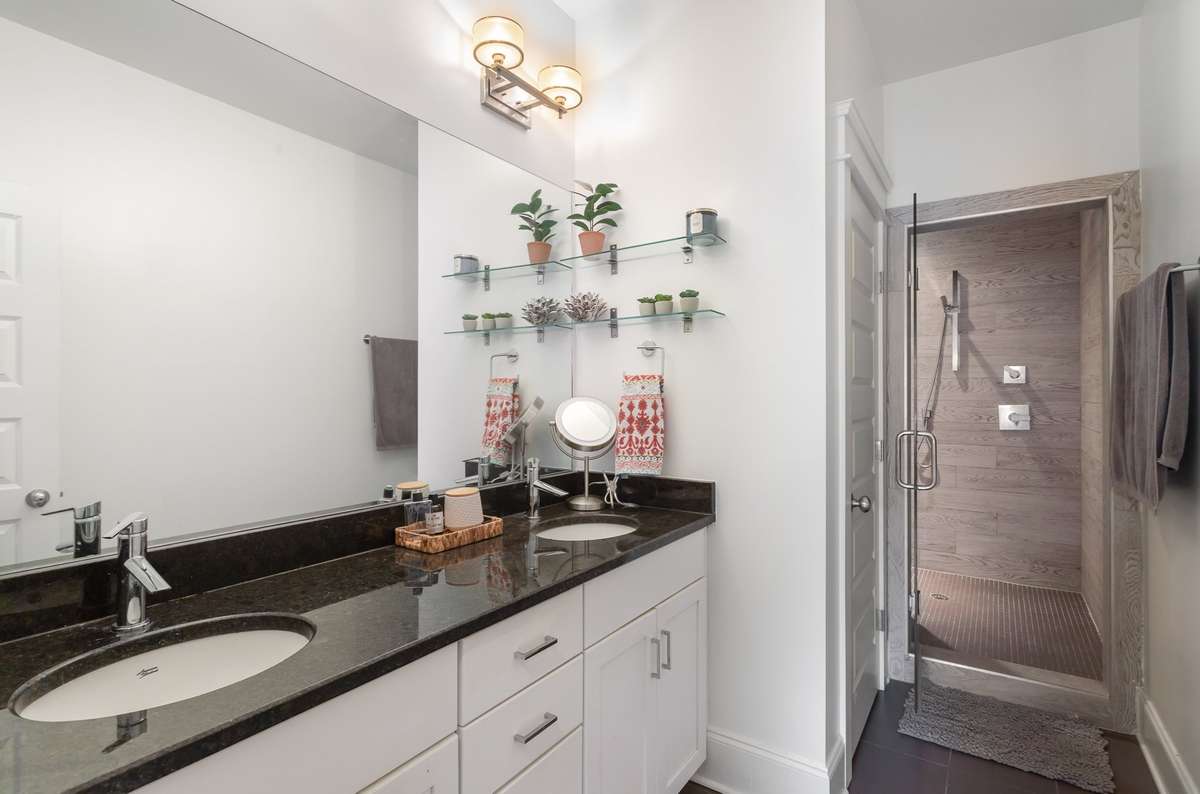 Primary bathroom offers lot's of counter space and features a double vanity and a large walk-in tile shower!