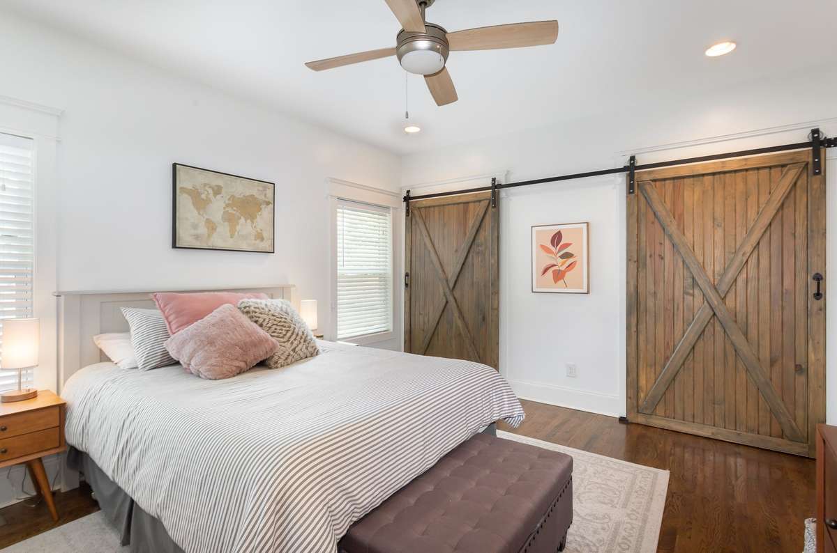 Another view of the primary suite, featuring barn doors that open to a spacious closet area.