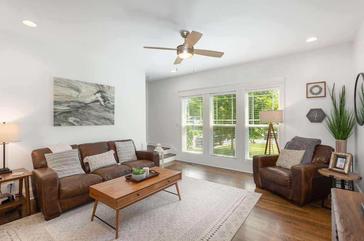 Bright and inviting living room with large windows for abundant natural light, and a comfortable, open layout. Neutral finishes and clean lines create a warm, functional space ideal for both relaxing and entertaining.