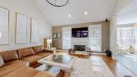 Open concept great room with high ceilings & a fireplace.