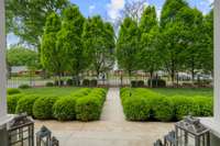 The view from the front porch to the front gates and the lush boxwood gardens