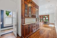 Impressive butlers pantry/custom hutch leading to the kitchen