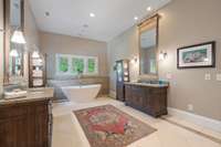 Spacious primary bath with two vanities, statement mirrors and soaking tub