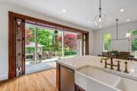 A custom walnut door completely opens to truly offer an outdoor living experience