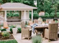 Perfect for al fresco dining! The outdoor dining area is perfectly situated above the cut stone retaining wall overlooking the pool