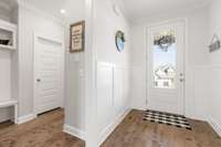 Foyer and hallway with drop zone leading to garage.