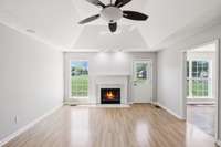 The Great Room features a wood-burning fireplace, tray ceiling, and ceiling fan.