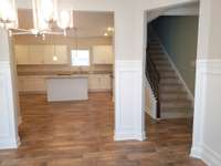 Looking from the dining toward the kitchen and the staircase to the second floor.