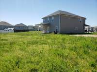Rear and side of the house from the back of the large yard.