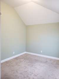 Bedroom 3 at the top of the stairs across from bedroom 2 and bathroom, also a vaulted ceiling.