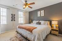 A cozy primary bedroom with a beautiful accent wall that brings added charm and character.