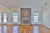 Gleaming oak floors accentuate the stone fireplace