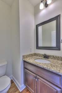 Half bath off of entryway with granite countertop