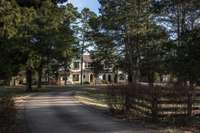 This home is situated well off the road with a winding drive through the pines and accented with a blackboard fence.