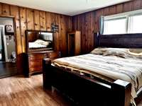 Primary Bedroom with plenty of room for a King size Bed. His and Her Closets 3 Windows and Outside Door.