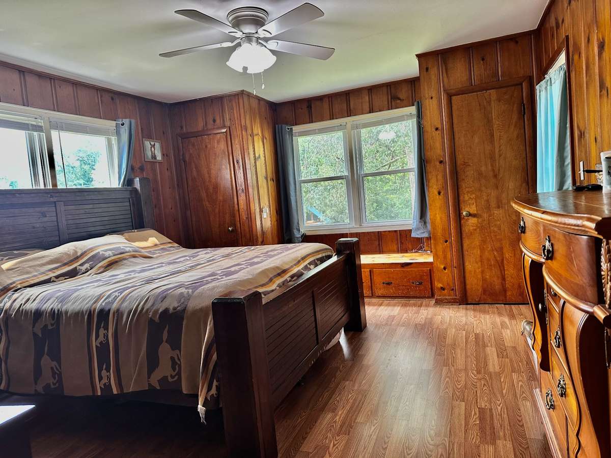 Primary Bedroom features beautiful Pine Walls and Hardwood floors with a Window built-in Bench.