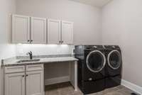 Large laundry room with sink, and counterspace. Laundry room connect to Master Bedroom closet