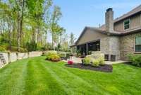 Treed backyard with rock retaining wall