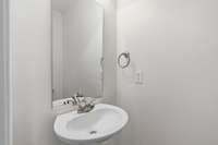 Half bath with pedestal sink located on the main level
