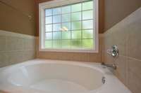 PRIMARY TUB WITH TILE & WINDOW ON THE BACK OF HOUSE