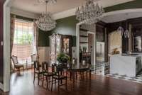 Symmetrical crystal chandeliers hang over an expandable dining room table