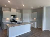 WHITE CABINETRY, SUBWAY TILE BACKSPLASH, QUARTZ COUNTERTOPS, PANTRY, GAS RANGE, TANKLESS GAS WATER HEATER