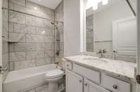Guest bath with all of the upgrades. Marble shower surround, new plumbing and light fixtures.
