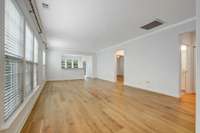 The living room features elegant crown molding and wide “Road to Home” white oak planks from Texture of Nashville. This light, natural flooring extends through the foyer, dining room, office, bedrooms, and closets for a seamless look.
