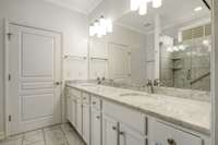 New marble countertops, floors and shower. The door leads to the spacious master bedroom closet!