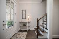 Entry has plenty of natural light. Steps leading upstairs are wood