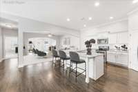 Virtually staged photo of the kitchen and great room.