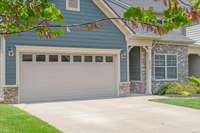 A spacious 2-car attached garage and concrete driveway with ample parking spaces.