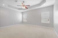 The primary bedroom is your personal retreat, complete with a stylish tray ceiling, ceiling fan, and new upgraded carpet for added comfort.