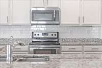 The tile backsplash & under-cabinet lighting are upgrades completed by the owner.