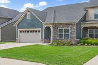 As you approach the front door, you'll be greeted by beautifully landscaped grounds and lush green grass in both the front and backyard.