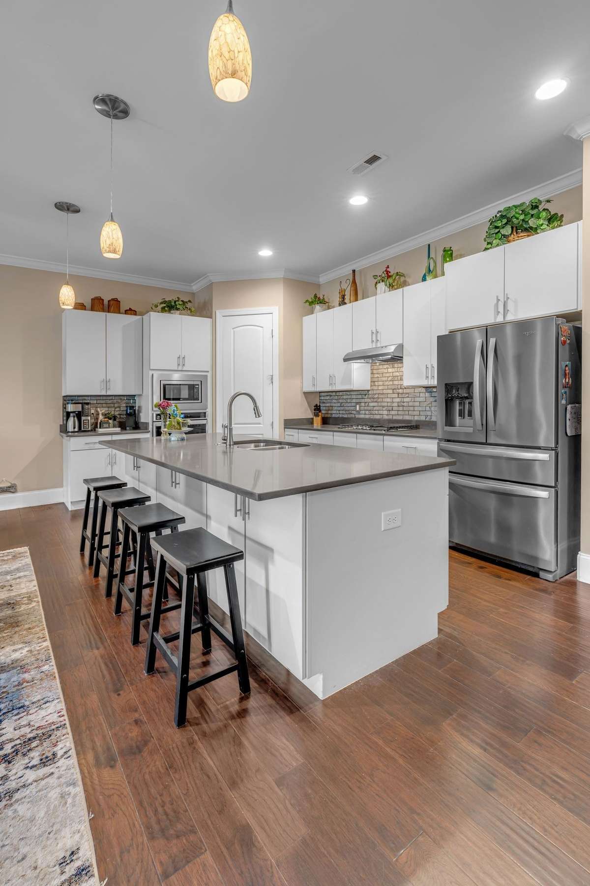 Beautiful Open Kitchen with island and Quartz counter tops. Fridge stays with home. New Pendant lighting above Island area.