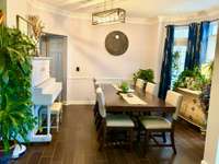 This formal Dining Room is warm & inviting. Front door is to the right of this photo.  Walkway past the piano leads to the kitchen. The floors look like wood but are tile!