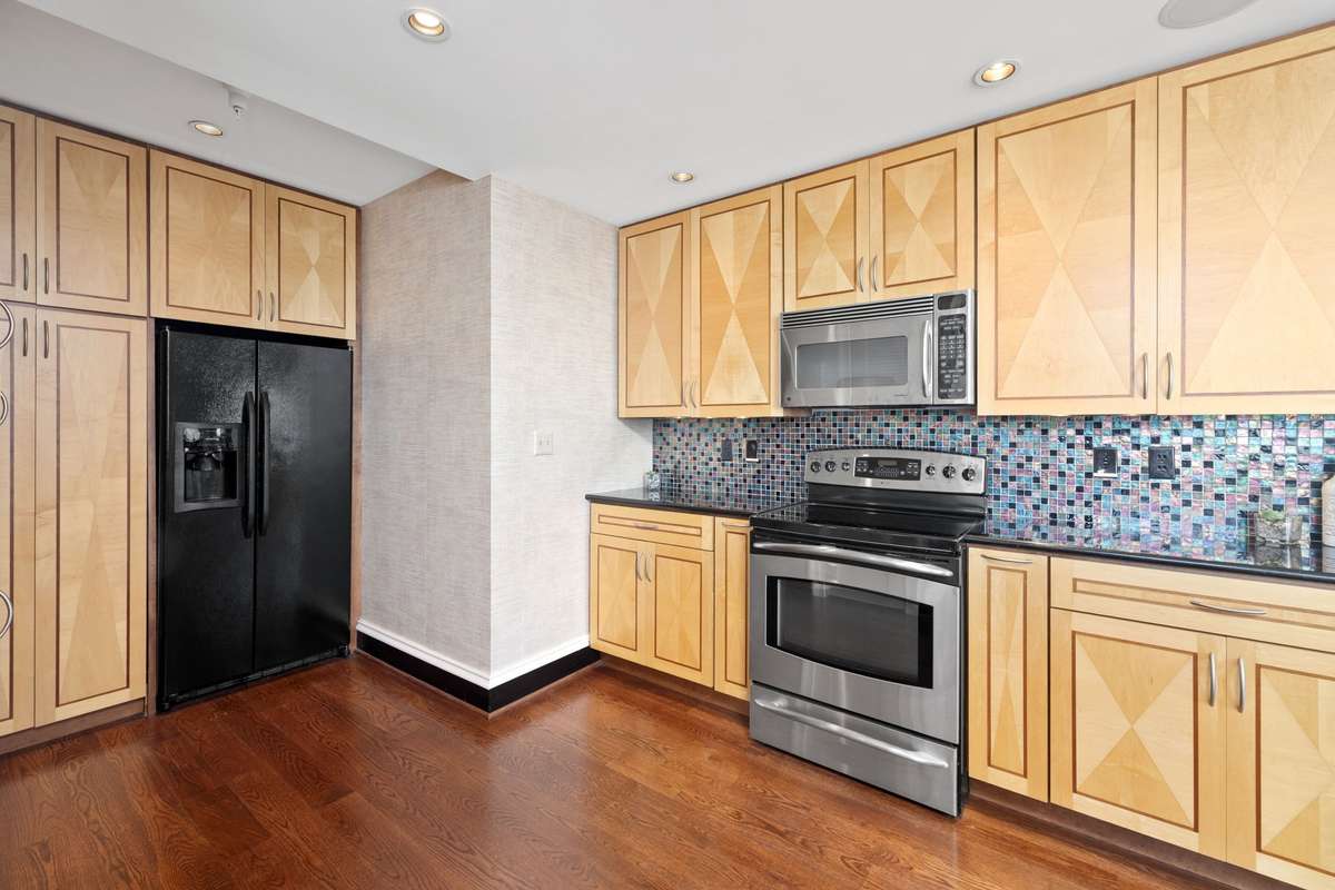 Multicolored tile backsplash and lots of custom cabinetry for storage!