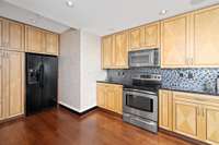 Multicolored tile backsplash and lots of custom cabinetry for storage!