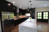 Kitchen with ceiling-height cabinets and cascade granite island