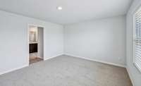 View of primary bedroom toward full bath.