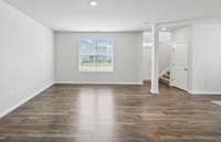 Living room with double windows overlooking the front yard. All downstairs windows have blinds.