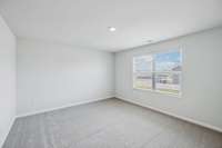 Primary bedroom with double windows overlooking the front yard.