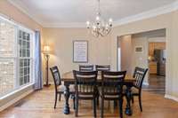 Front-facing dining room filled with natural light, featuring a large picture window and direct flow into the kitchen—ideal for everyday meals or entertaining.