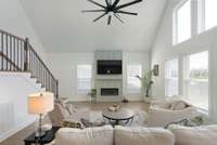 great room with electric firplace with board and batten surround, open railing going up the stairs