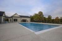 Saltwater pool has large steps to enter, fountains, and gorgeous view of the open field