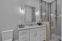 Ensuite Bathroom with glass shower and waterfall tile design